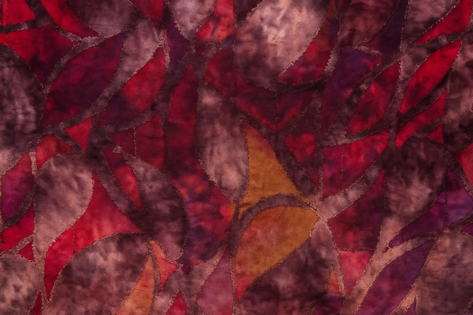 Textured fabric with red, brown, and orange leaf pattern